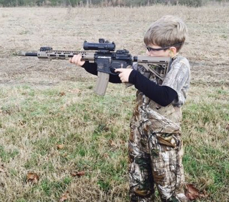 Boy hunting with Custom left hand Red Ryder Armory AR Sporting Rifle In .223/5.56