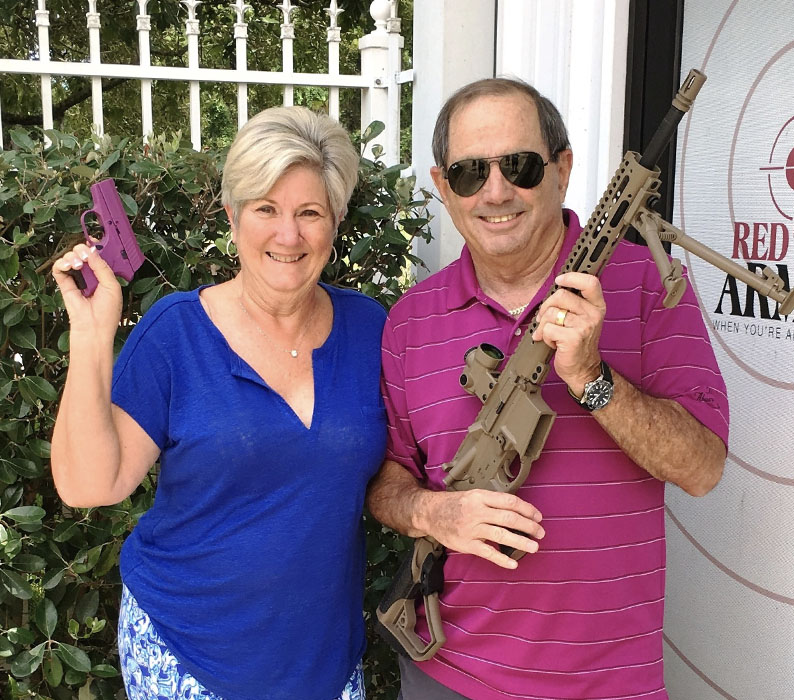 Happy customers posing with RM380 Pistol in Custom Purple with Cerakote finish and Red Ryder Custom Sporting Rifle in Flat Dark Earth (FDE) with Trijicon Optic sold at Red Ryder Armory in Jacksonville FL